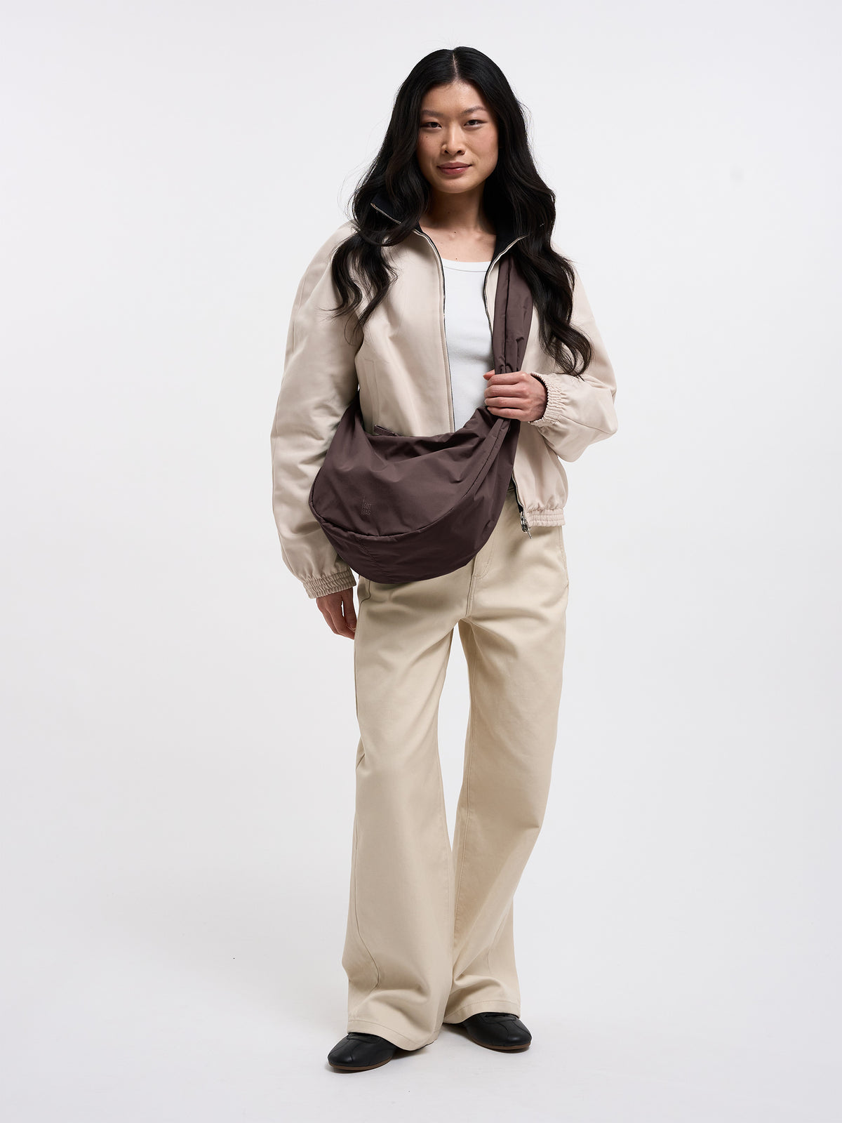 MOON BAG RUFFLE Tasche in sea lion (dunkles Schokobraun) von einer Frau crossbody getragen.