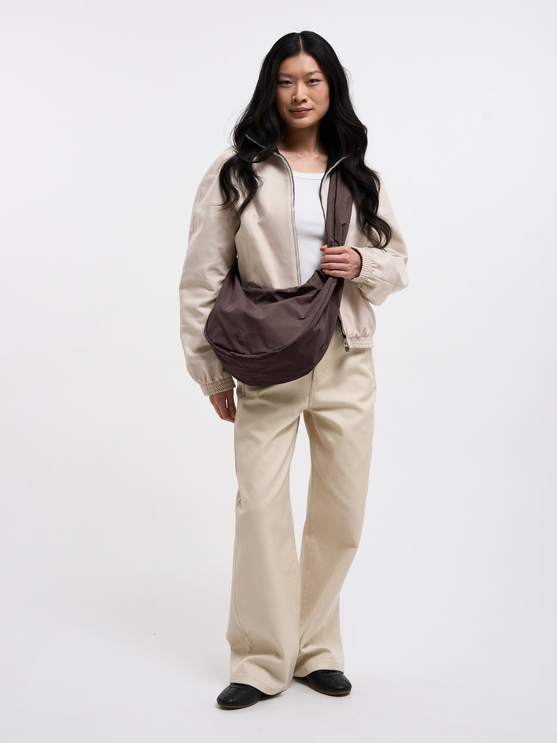MOON BAG RUFFLE Tasche in sea lion (dunkles Schokobraun) von einer Frau crossbody getragen.