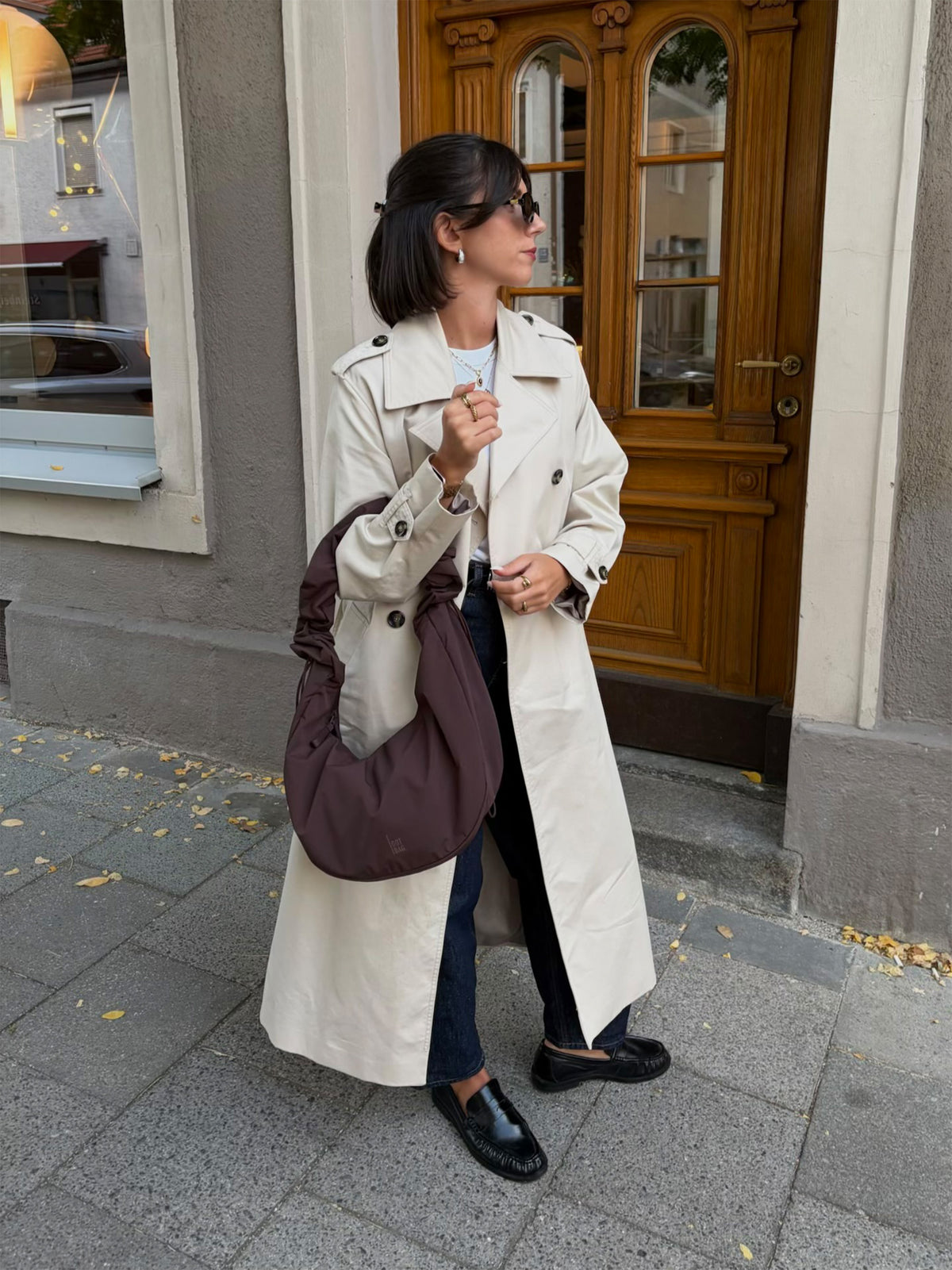 MOON BAG RUFFLE borsa in sea lion (marrone cioccolato scuro) tenuta in mano da una donna.