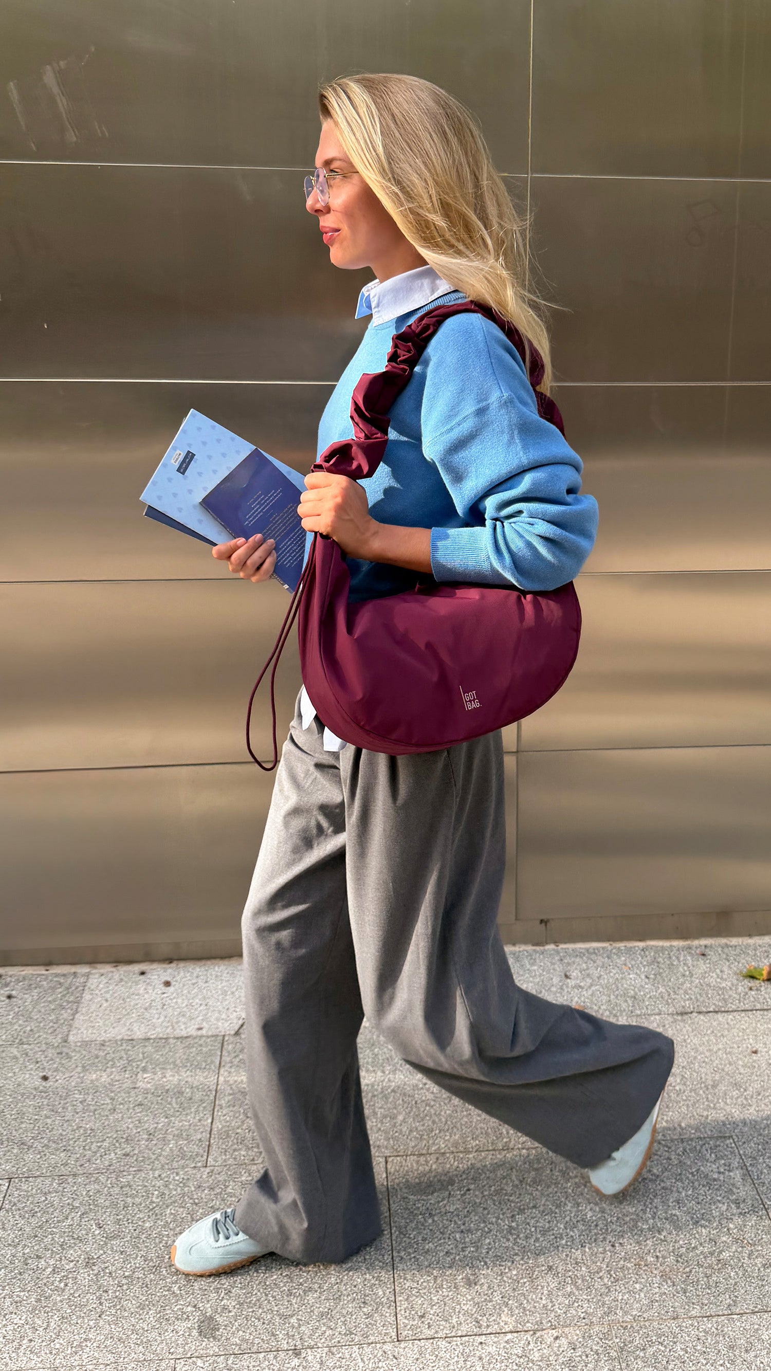 MOON BAG RUFFLE borsa in kraken (bordeaux) portata sulla spalla da una donna.