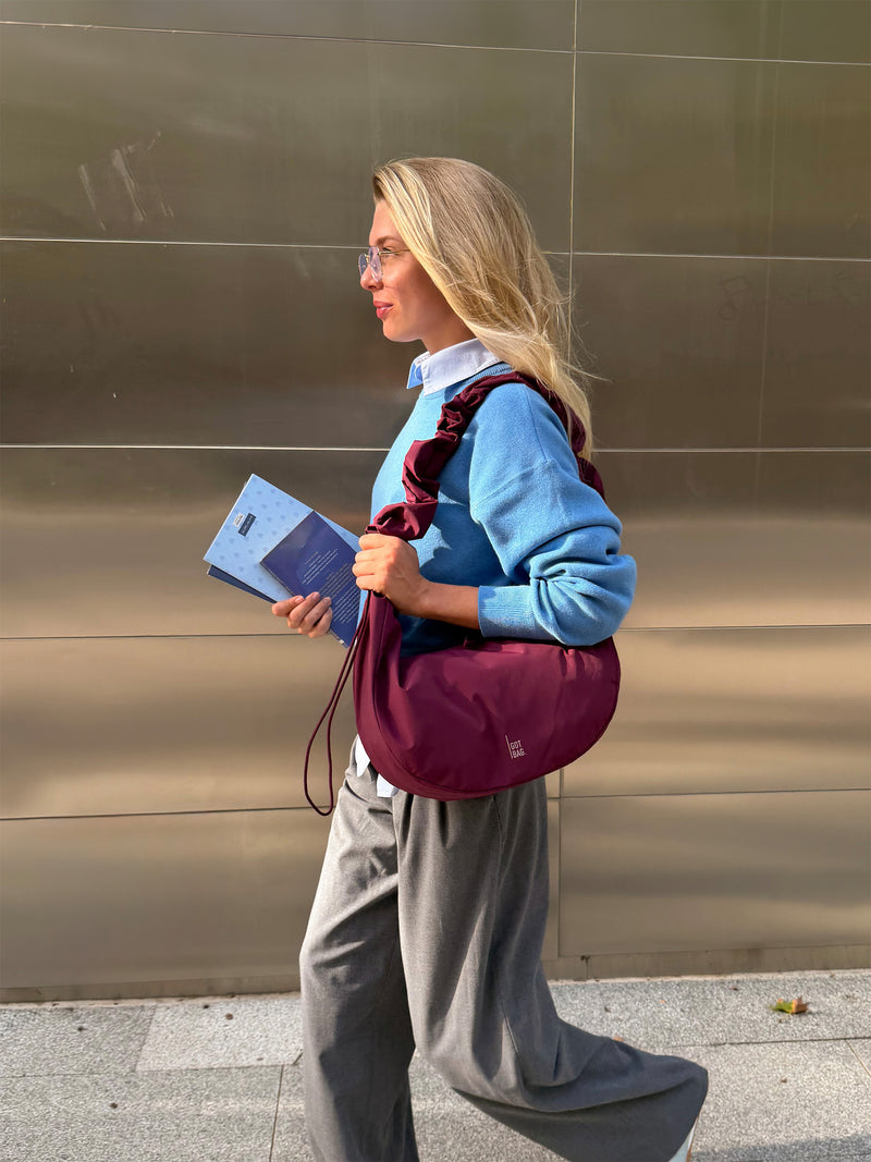 MOON BAG RUFFLE taška v kraken (burgundské) nošena přes tělo ženou.