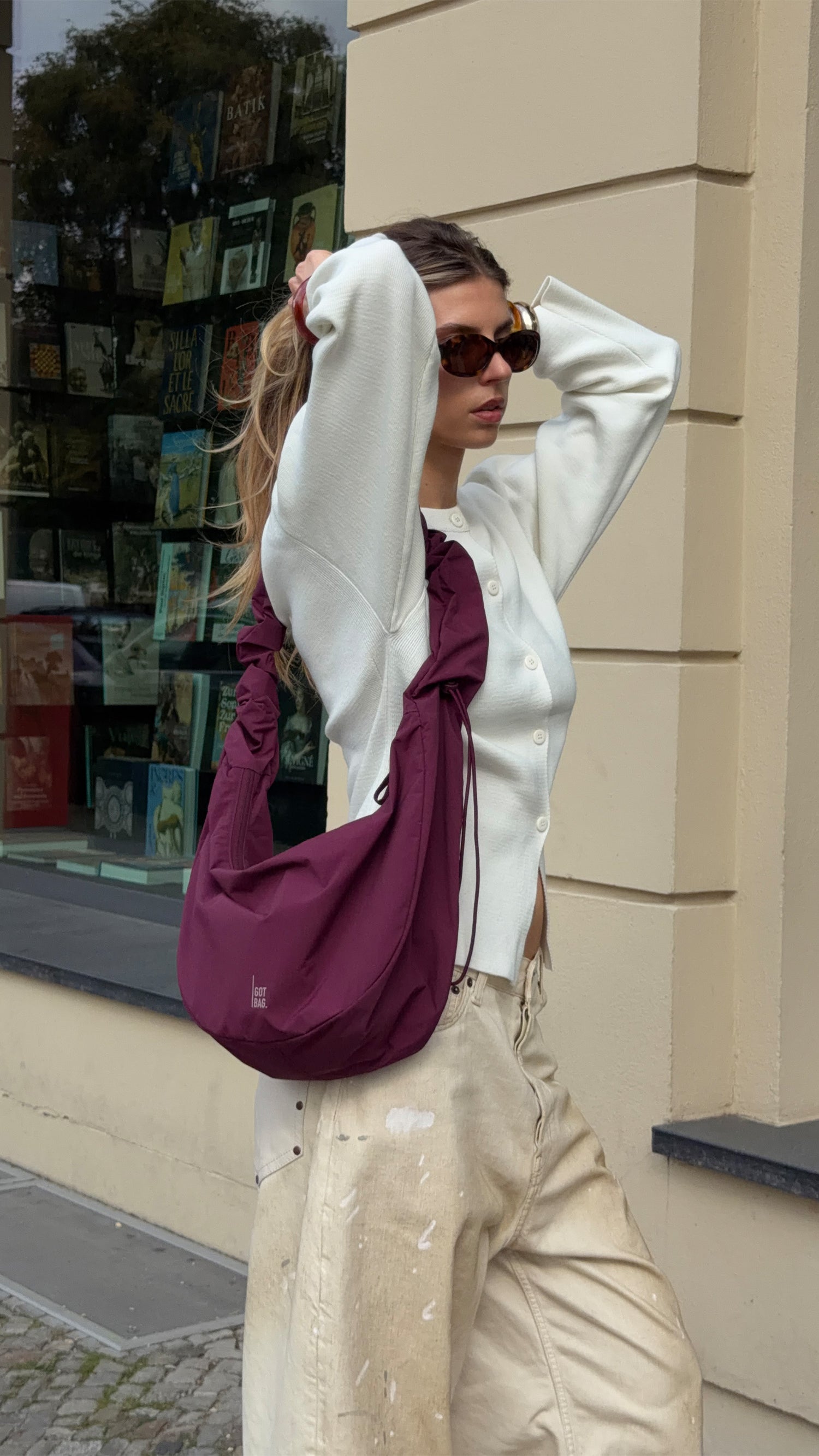 MOON BAG RUFFLE borsa in kraken (bordeaux) portata a tracolla da una donna.