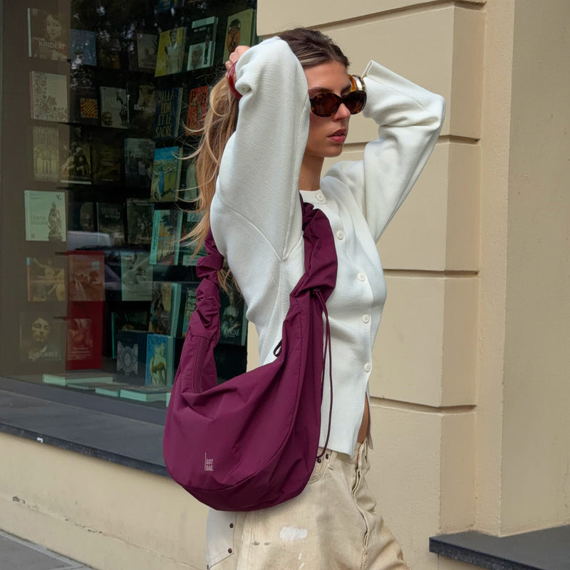 MOON BAG RUFFLE tas in kraken (Wijnrood) crossbody gedragen door een vrouw.