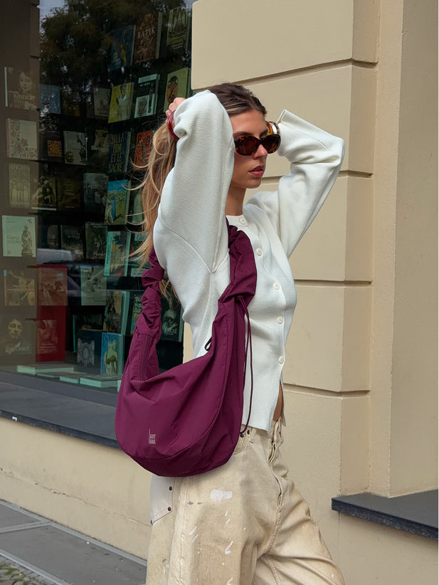 MOON BAG RUFFLE tas in kraken (Wijnrood) crossbody gedragen door een vrouw.