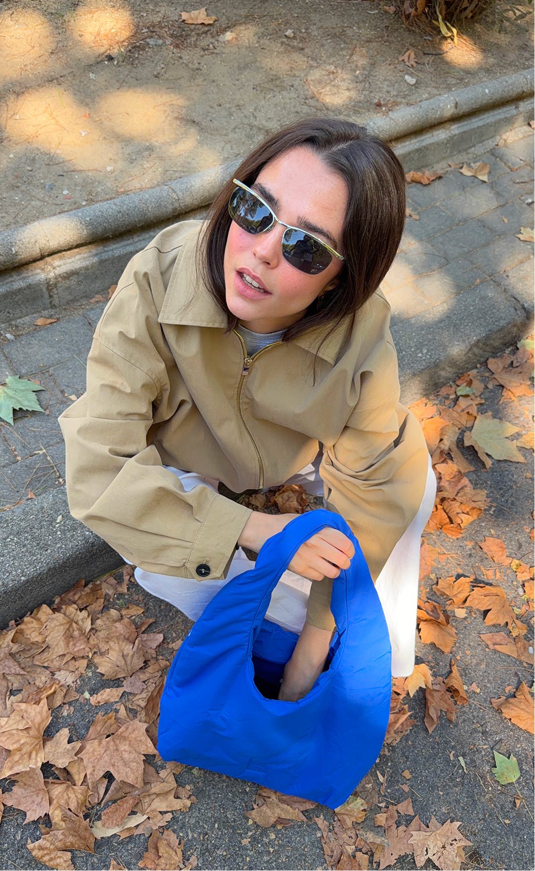 CLOUD SHOULDER BAG Tasche in cobalt (leuchtendes Kobaltblau) von einer Frau in der Hand gehalten.