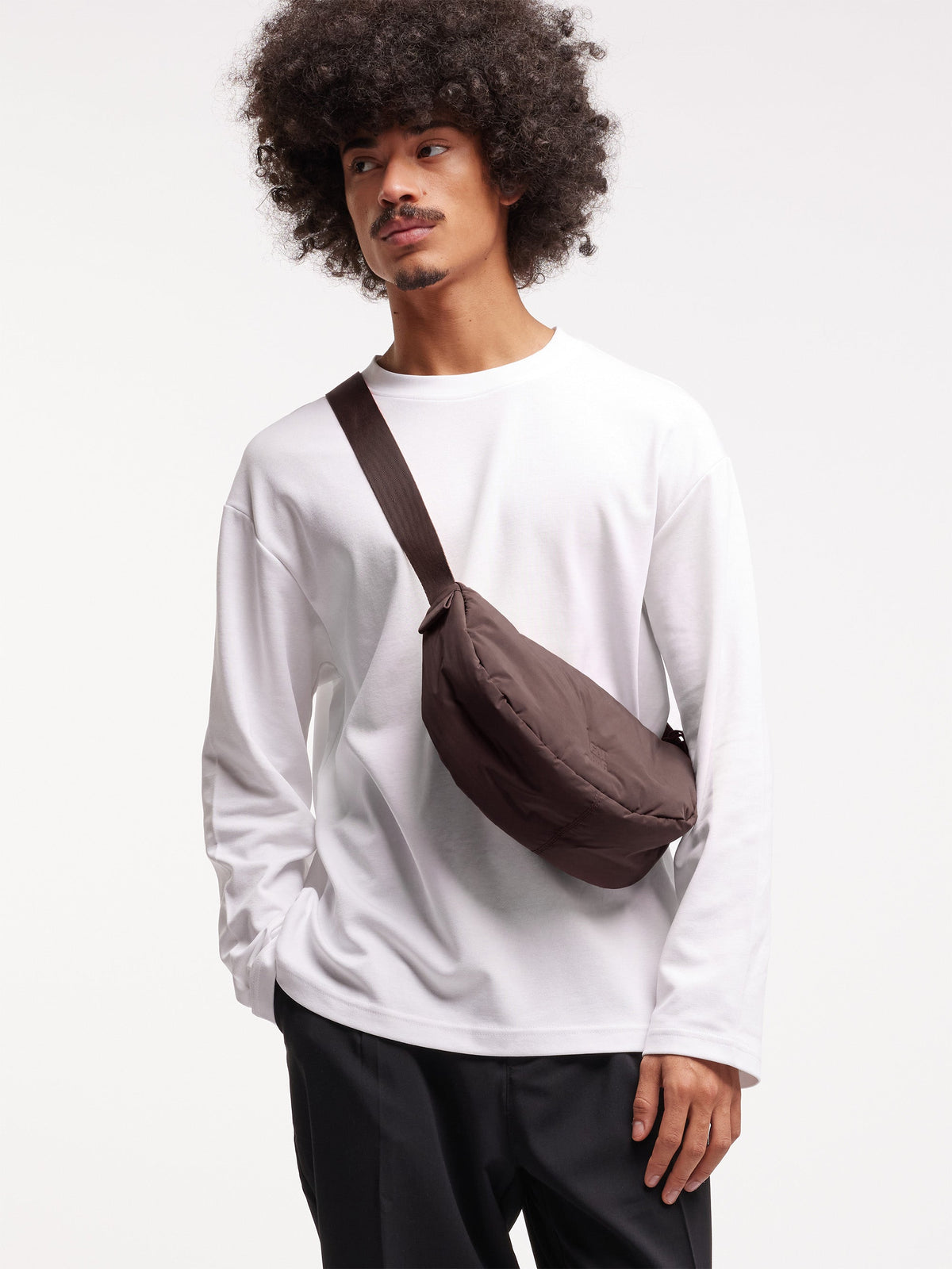 CLOUD MOON BAG SMALL Tasche in sea lion (dunkles Schokobraun) von einem Mann getragen.