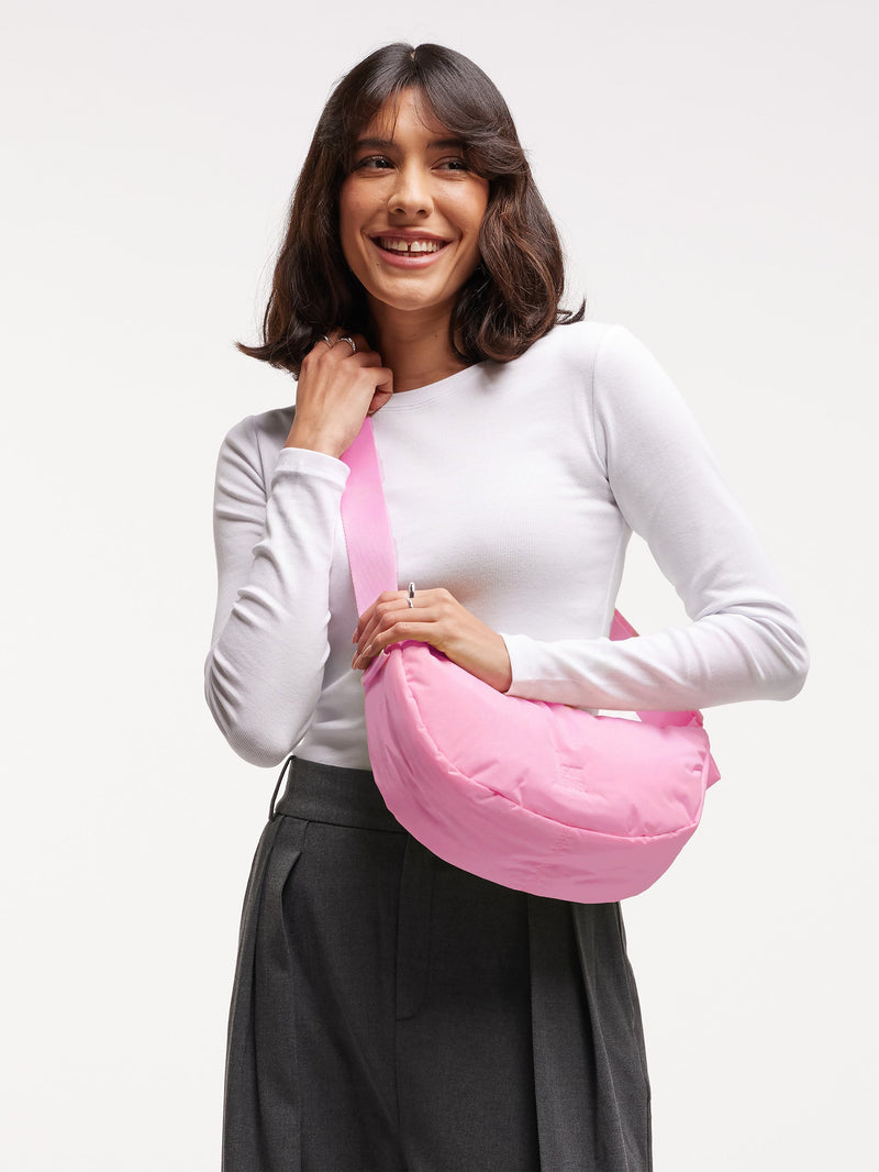 CLOUD MOON BAG SMALL Tasche in sea rose von einer Frau getragen.