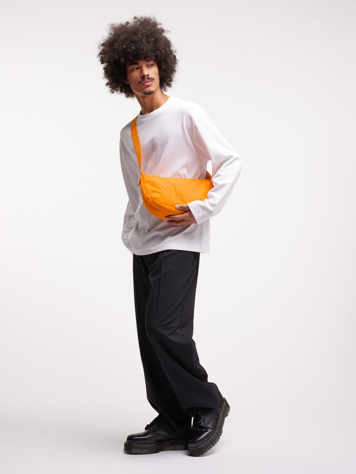 CLOUD MOON BAG SMALL Tasche in clown fish von einem Mann getragen.