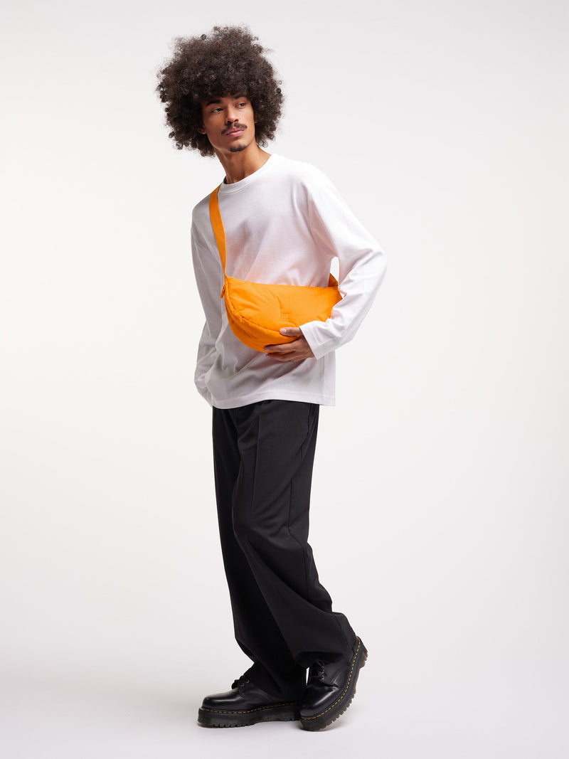 CLOUD MOON BAG SMALL Tasche in clown fish von einem Mann getragen.
