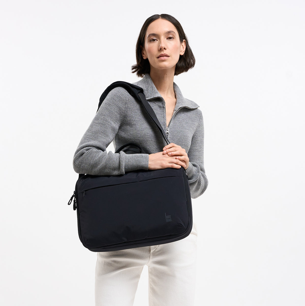 COMMUTER BAG Tasche in black (Schwarz) von einer Frau über der Schulter getragen.