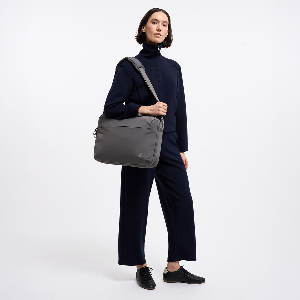 COMMUTER BAG Tasche in shark (Dunkelgrau) von einer Frau über der Schulter getragen.