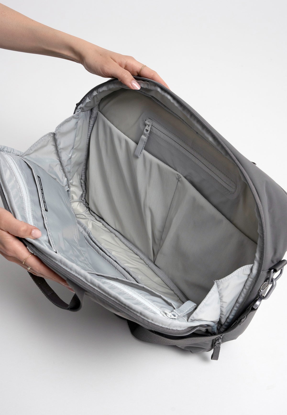 COMMUTER BAG Tasche in shark (Dunkelgrau) von einer Frau geöffnet, zeigt das organisierte Innenleben mit vielen Fächern.