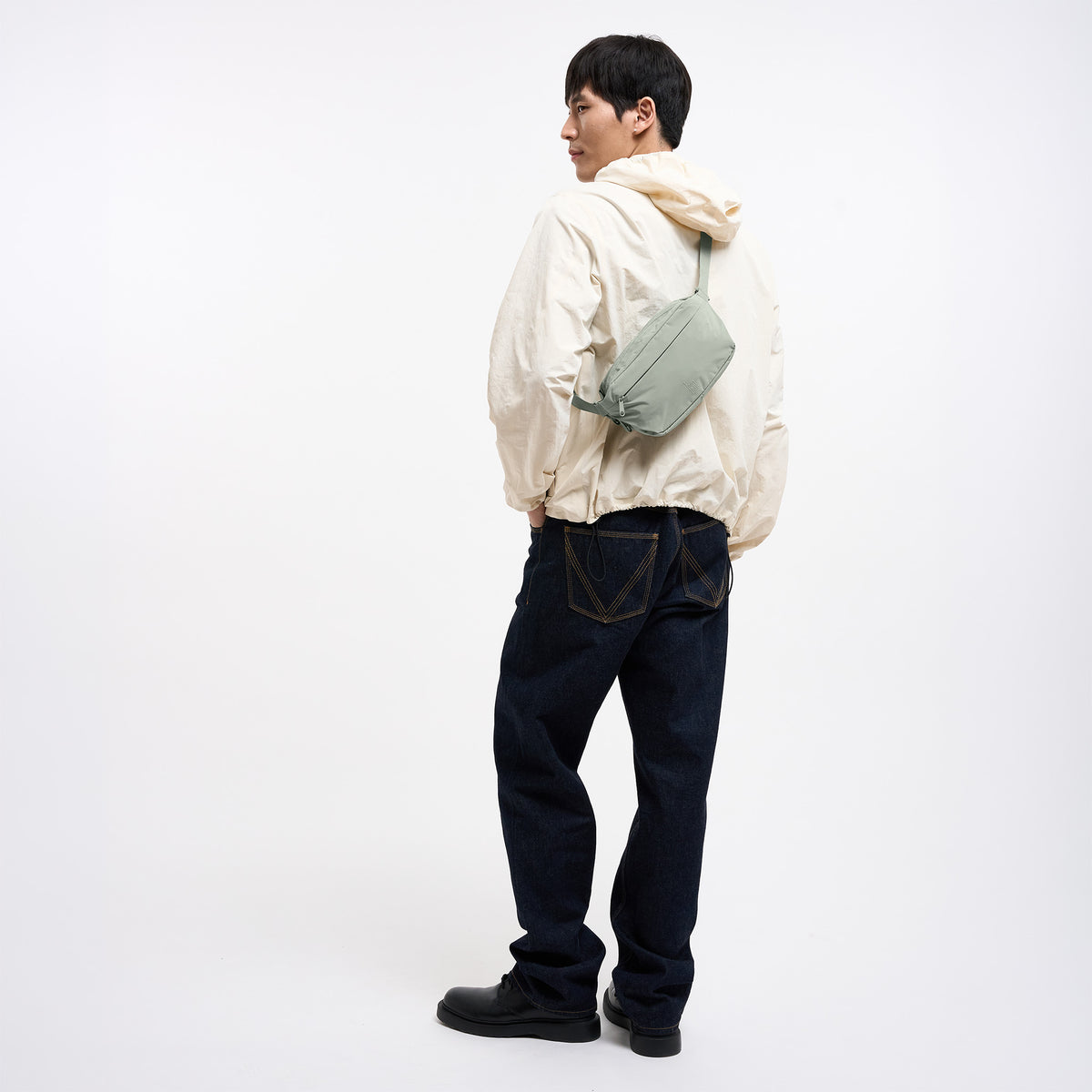 ADAPT SLING BAG Tasche in bass (Salbeigrün) von einem Mann crossbody getragen.