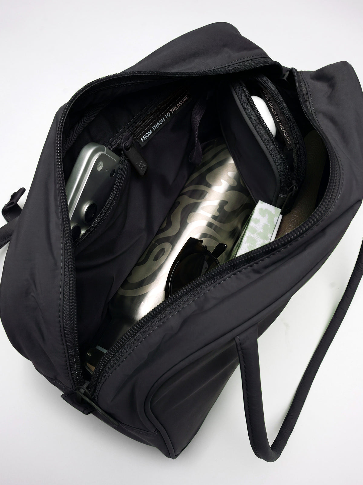 STRIKE BAG Tasche in black (Schwarz) von oben mit Blick ins Innere, gefüllt mit Gegenständen.