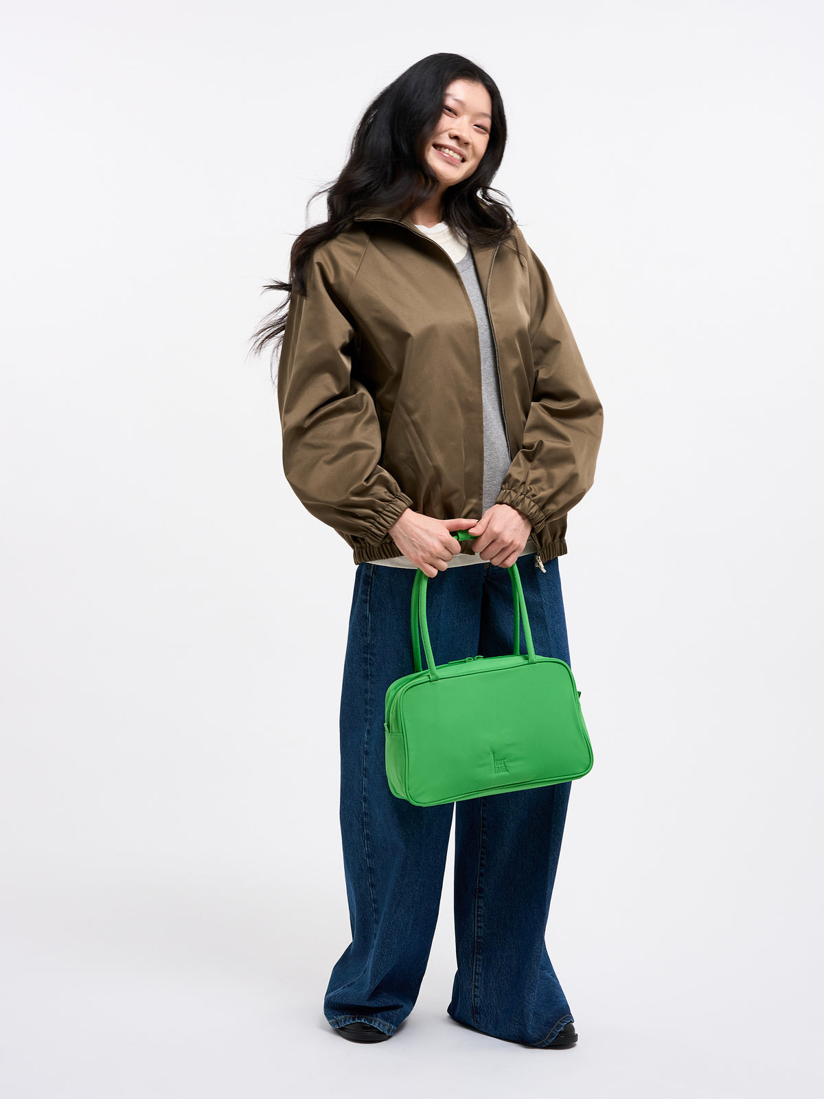 STRIKE BAG Tasche von einer Frau in der Hand gehalten.