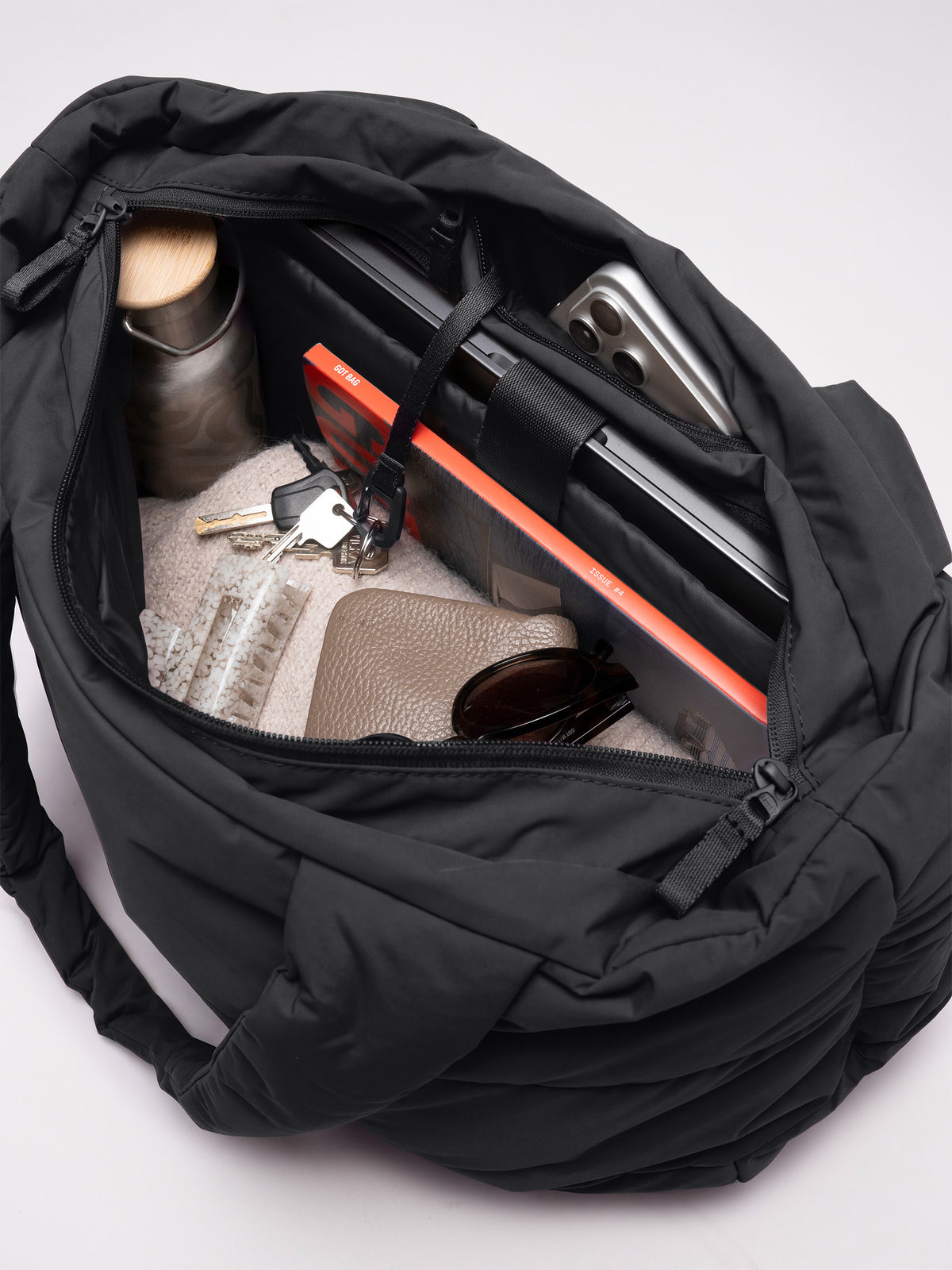 PUFFER HORIZON TOTE BAG Tasche in black (Schwarz) als Innenansicht mit Laptop, Smartphone, Wasserflasche, Schlüsseln und Geldbörse.