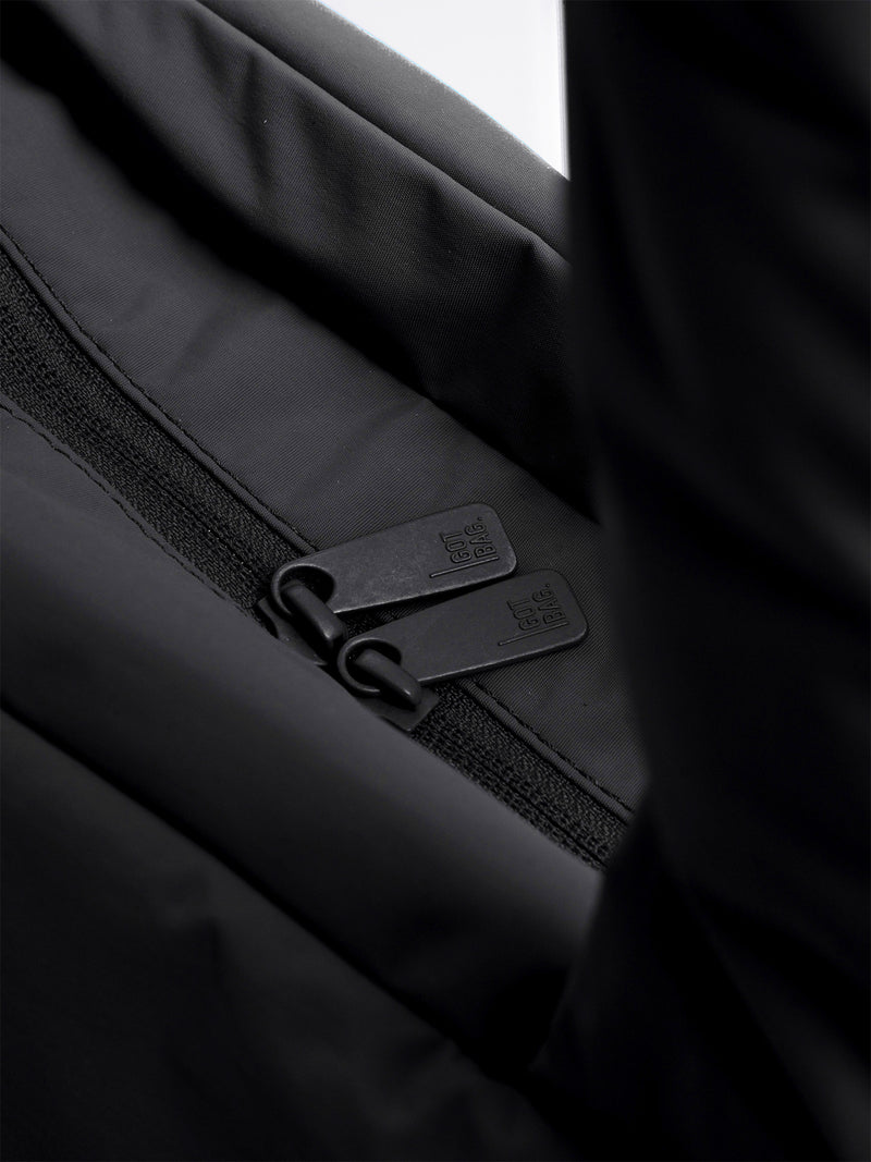 PUFFER HORIZON TOTE BAG Tasche in black (Schwarz) mit GOT BAG.-Prägung an den Reißverschlussanhängern als Detailaufnahme.