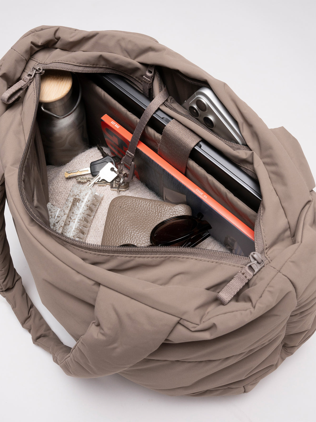 PUFFER HORIZON TOTE BAG Tasche in oyster (klassisches Taupe-Braun) Innenansicht mit Laptop, Handy, Schlüsseln und Gegenständen.