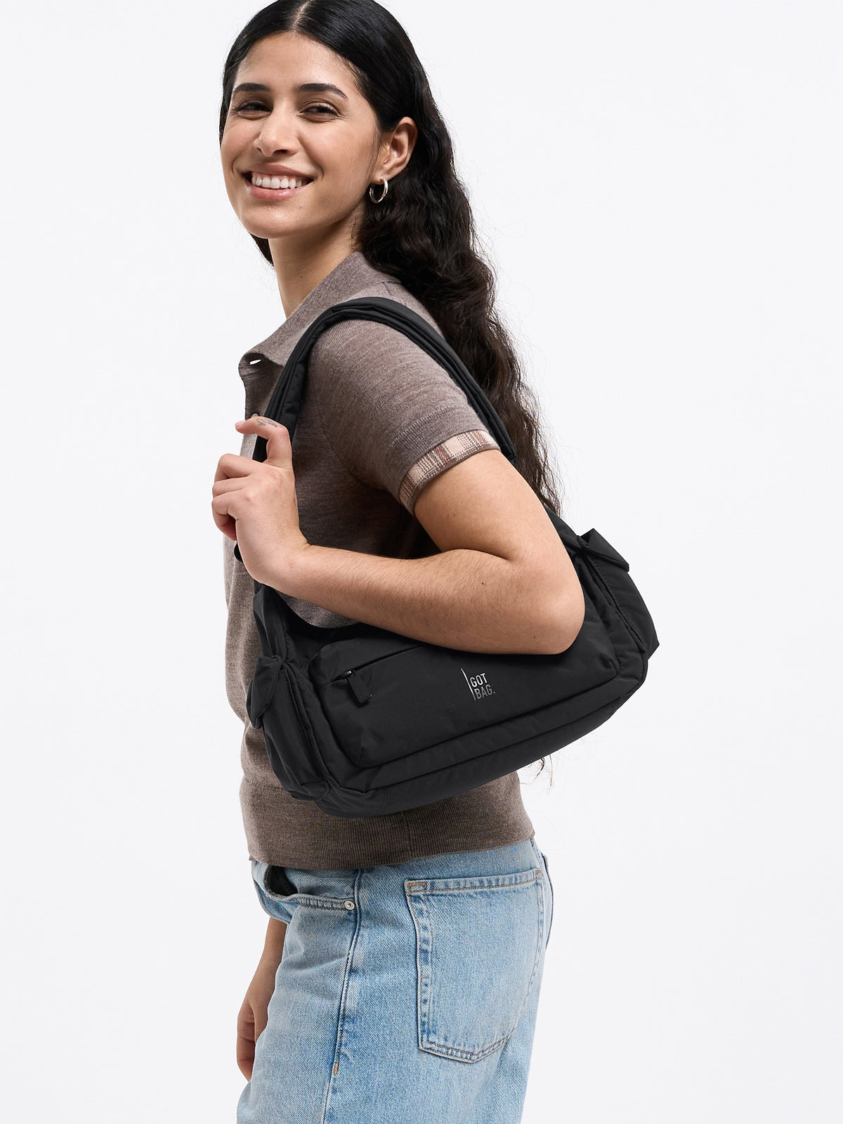 POCKET BAG SMALL Tasche in black (Schwarz) von einer Frau über der Schulter getragen.