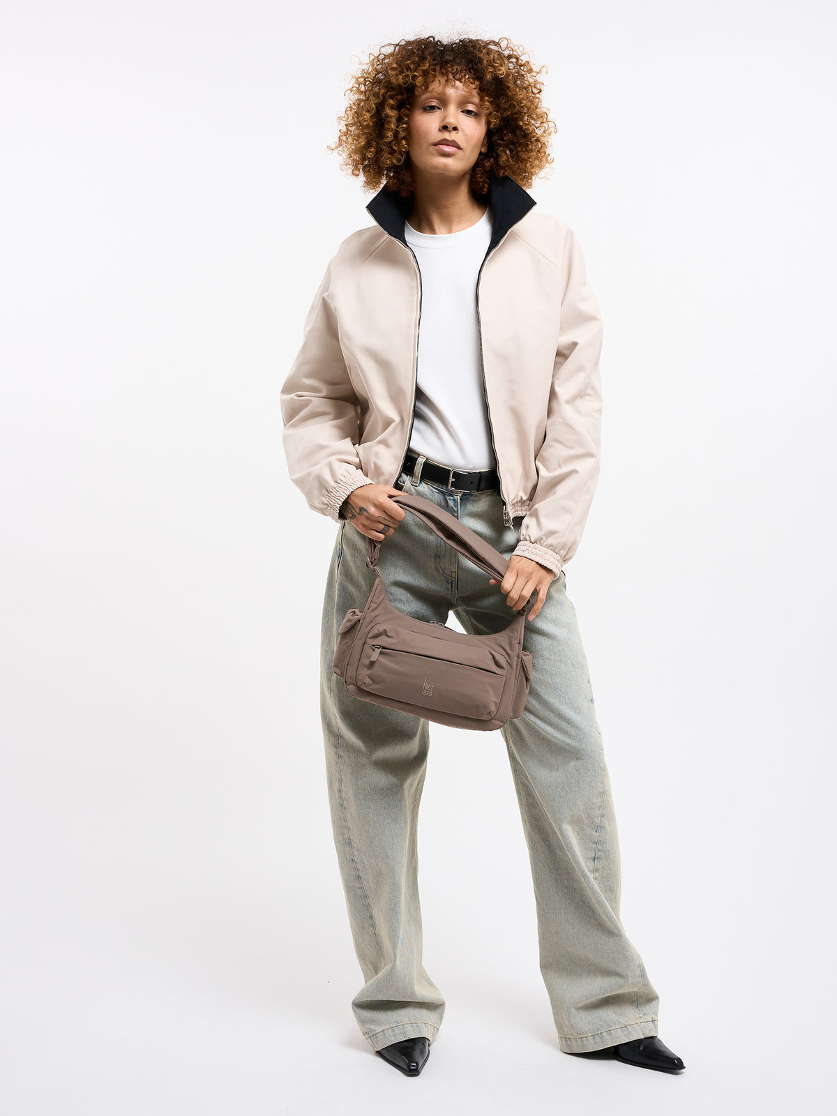 POCKET BAG SMALL Tasche in oyster (klassisches Taupe-Braun) von einer Frau über der Schulter getragen.
