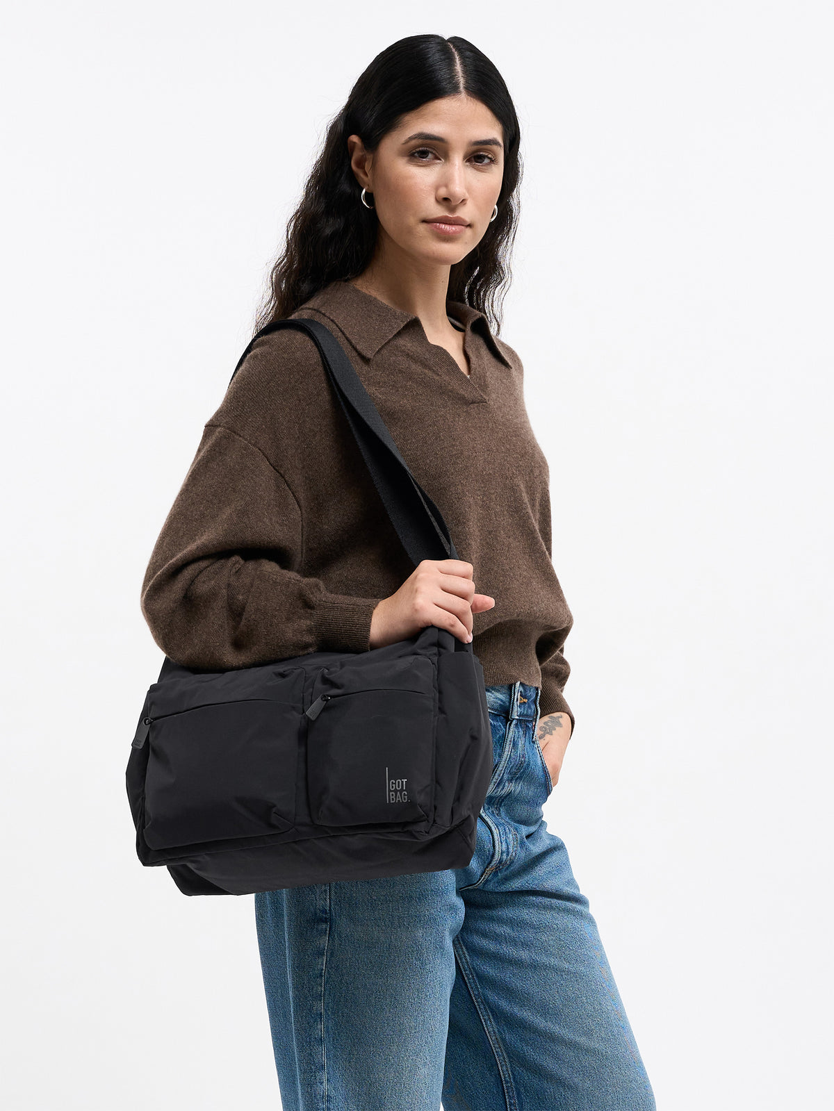 POCKET SLING BAG Tasche in black (Schwarz) von einer Frau über der Schulter getragen.