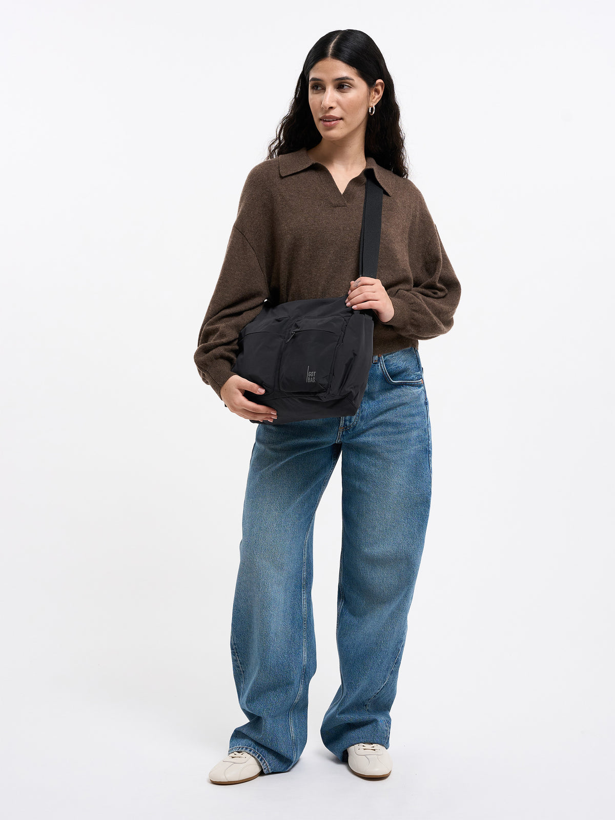 POCKET SLING BAG Tasche in black (Schwarz) von einer Frau crossbody getragen.
