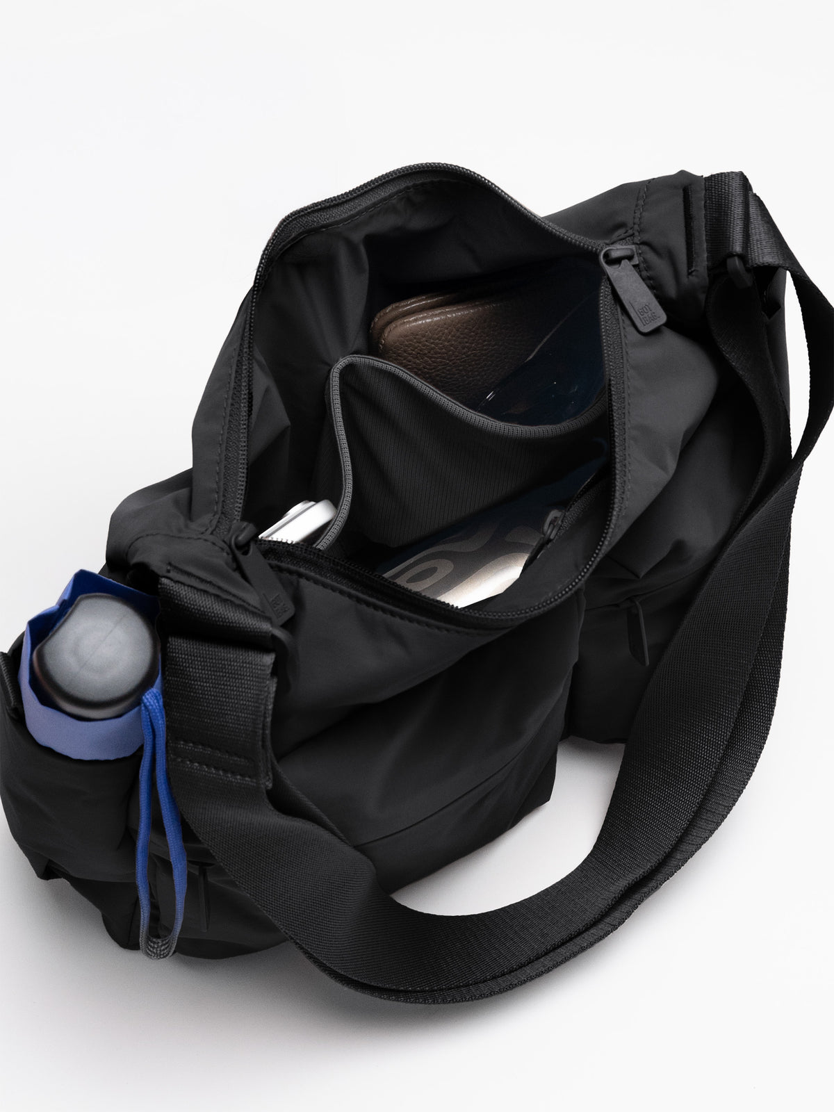 POCKET SLING BAG Tasche in black (Schwarz) mit gefülltem Innenraum.