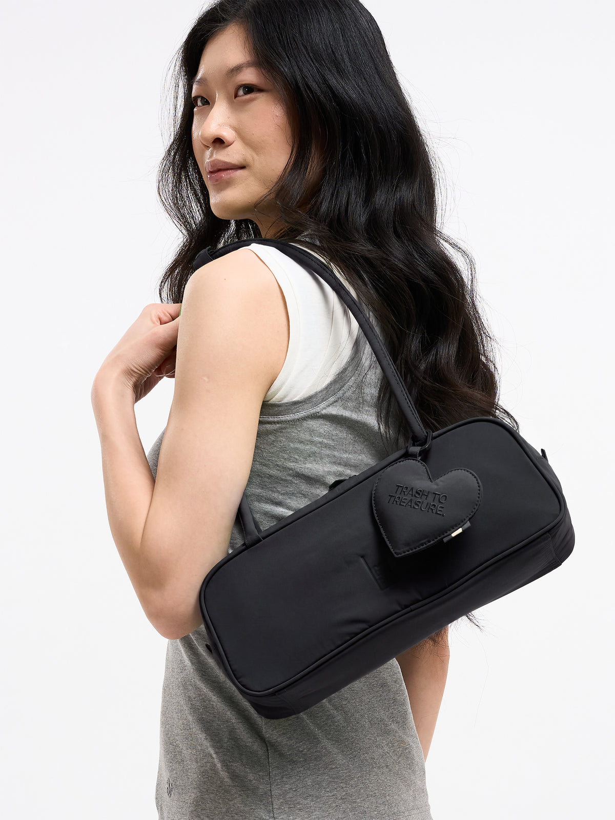 STRIKE BAG SMALL Tasche in black (Schwarz) von einer Frau über der Schulter getragen.