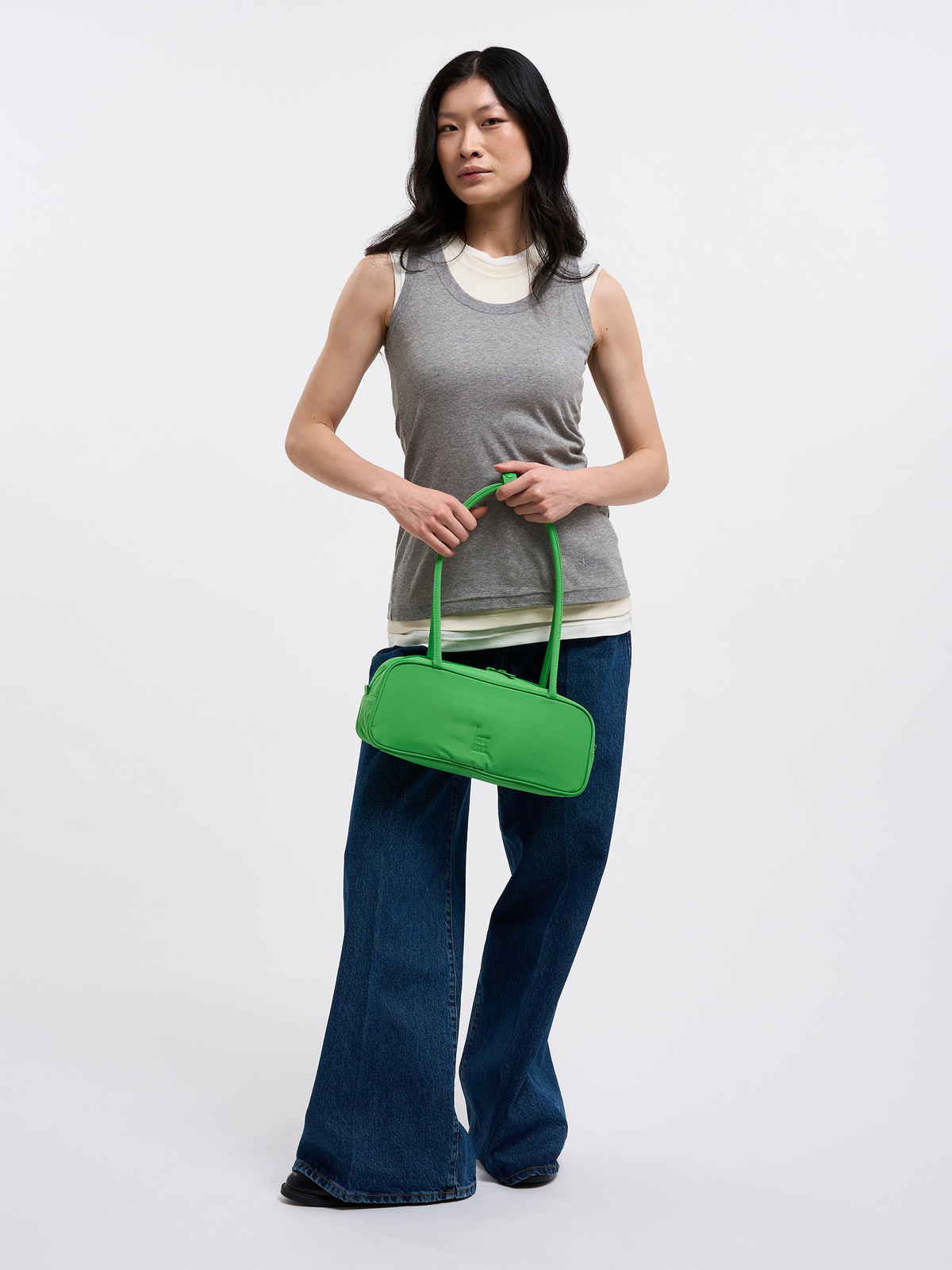 STRIKE BAG SMALL Tasche in leaf von einer Frau in der Hand gehalten.