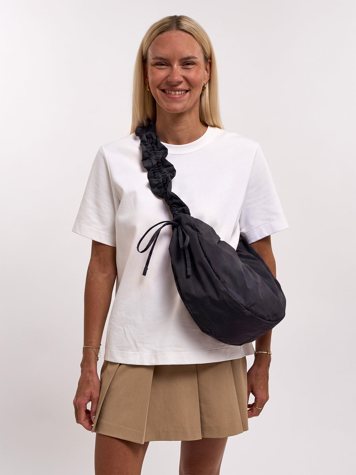 MOON BAG BOW Tasche in black (Schwarz) von einer Frau crossbody getragen.