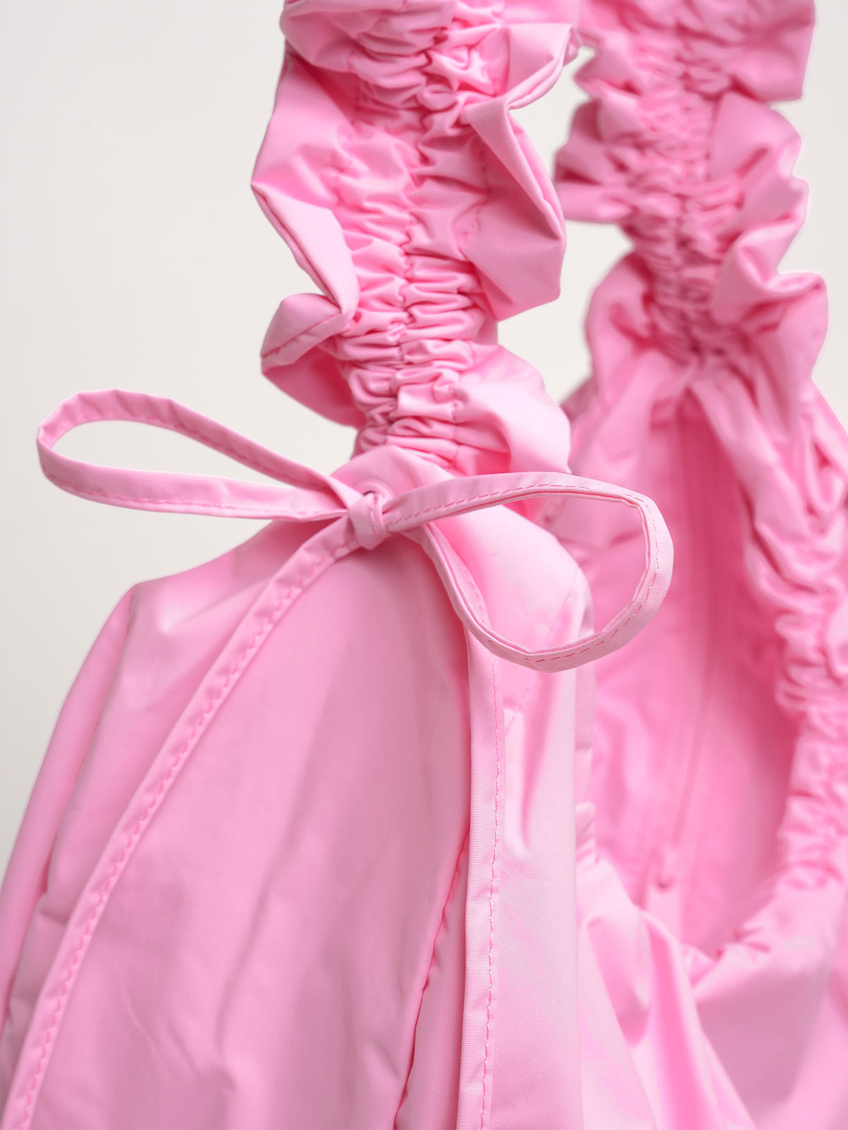 MOON BAG BOW Tasche in sea rose (sattes Pastell-Rosa) mit Schleife und gerafftem Stoff als Detailaufnahme.