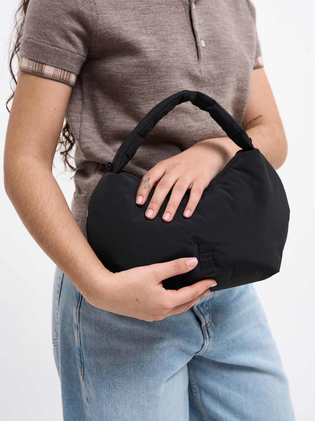 CLOUD BEAD BAG Tasche in black (Schwarz) von einer Frau in der Hand gehalten.