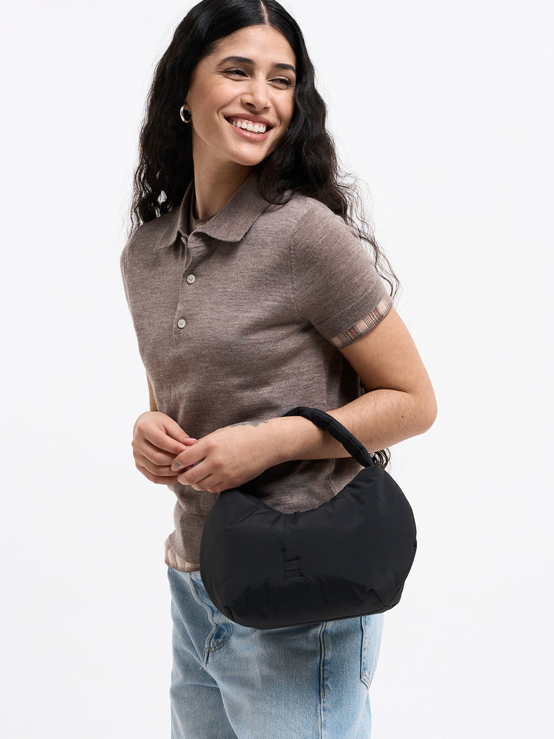 CLOUD BEAD BAG Tasche in black (Schwarz) von einer Frau in der Hand gehalten.
