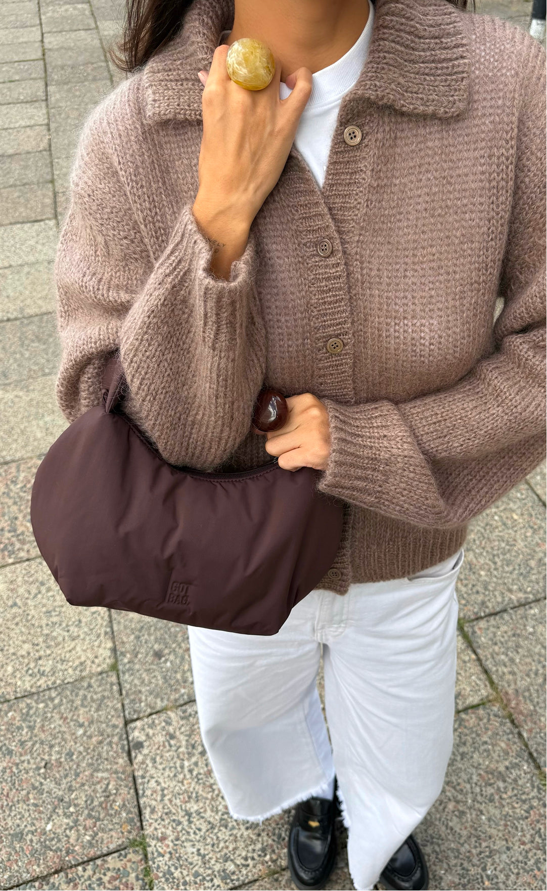 CLOUD BEAD BAG sac en sea lion (brun chocolat foncé) tenu dans la main par une femme.