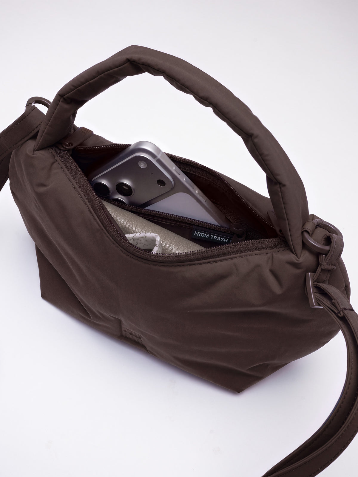 CLOUD BEAD BAG Tasche in sea lion (dunkles Schokobraun) mit Blick ins offene Innere, gefüllt mit einem Smartphone.