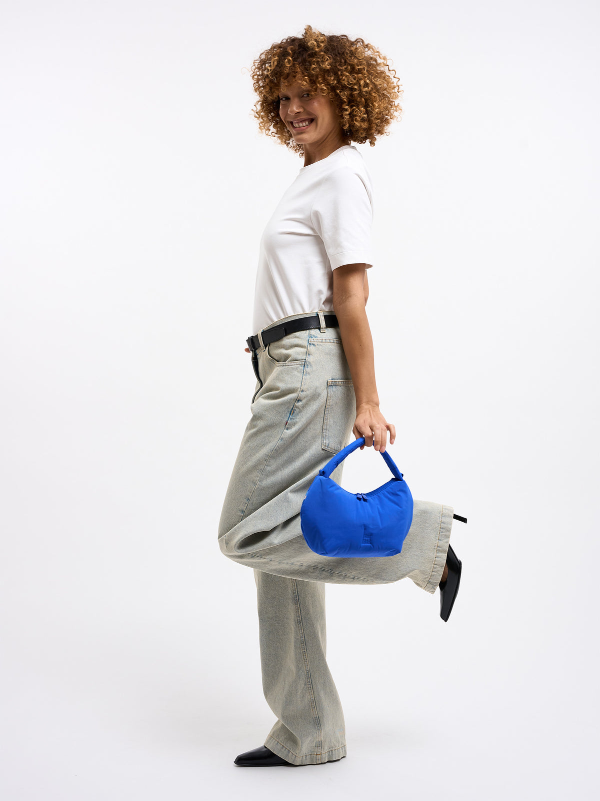 CLOUD BEAD BAG Tasche in cobalt (leuchtendes Kobaltblau) von einer Frau in der Hand gehalten.