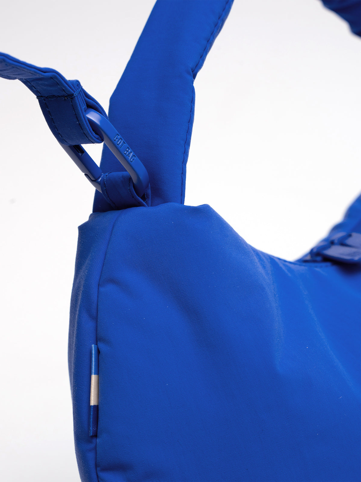 CLOUD BEAD BAG Tasche in cobalt (leuchtendes Kobaltblau) mit Karabiner und GOT BAG Schriftzug als Detailaufnahme.