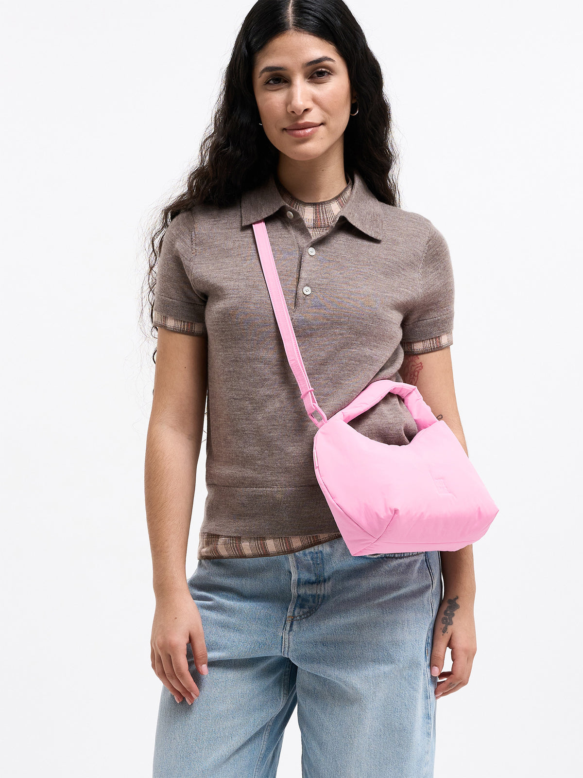 CLOUD BEAD BAG Tasche in sea rose (sattes Pastell-Rosa) von einer Frau crossbody getragen.