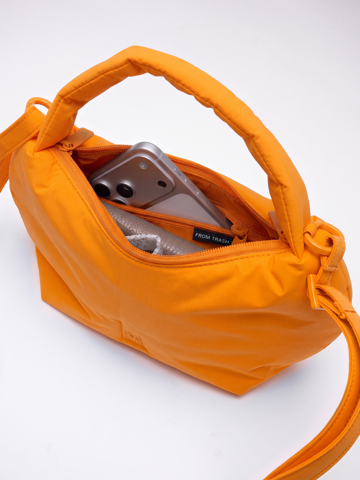 CLOUD BEAD BAG Tasche in clownfish (leuchtendes Orange-Gelb), Innenansicht mit Handy und Inhalt.
