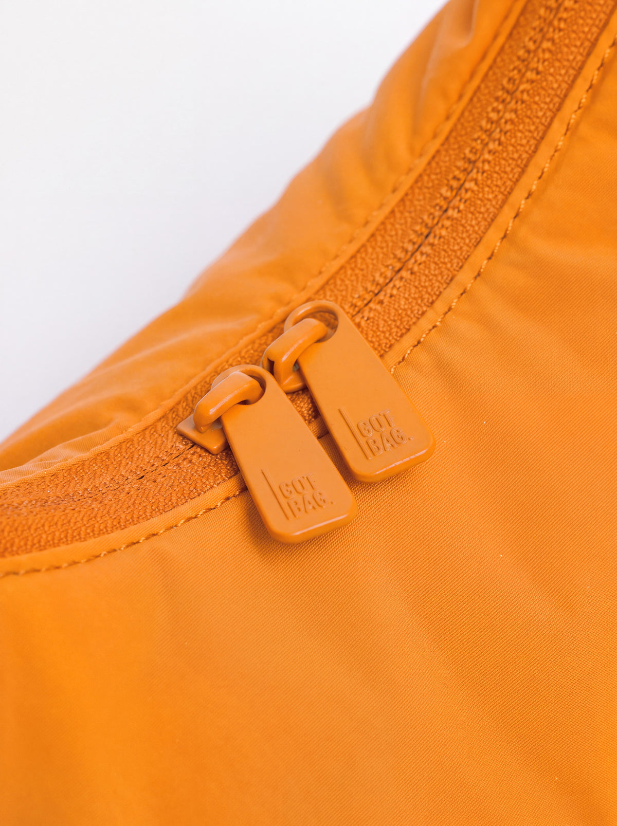 CLOUD BEAD BAG Tasche in clownfish (leuchtendes Orange-Gelb) als Detailaufnahme des geöffneten Reißverschlusses.