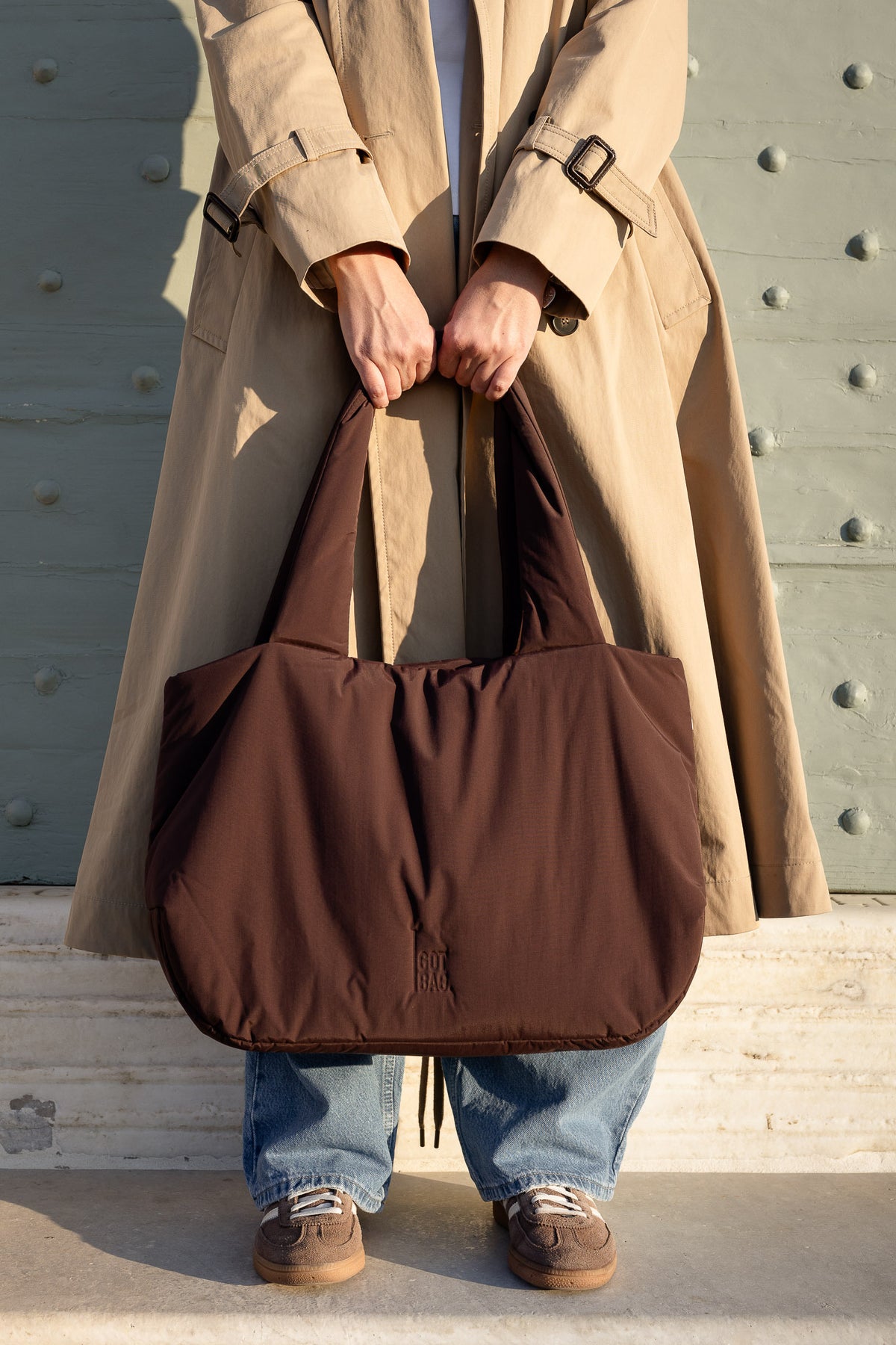 CLOUD HORIZON TOTE BAG sac en sea lion (brun chocolat foncé) tenu par une femme des deux mains.