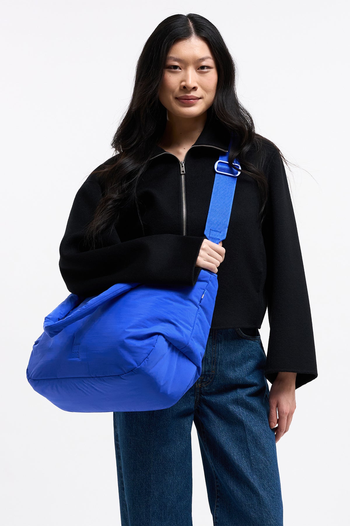 CLOUD HORIZON TOTE BAG Tasche in cobalt (leuchtendes Kobaltblau) von einer Frau über der Schulter getragen.