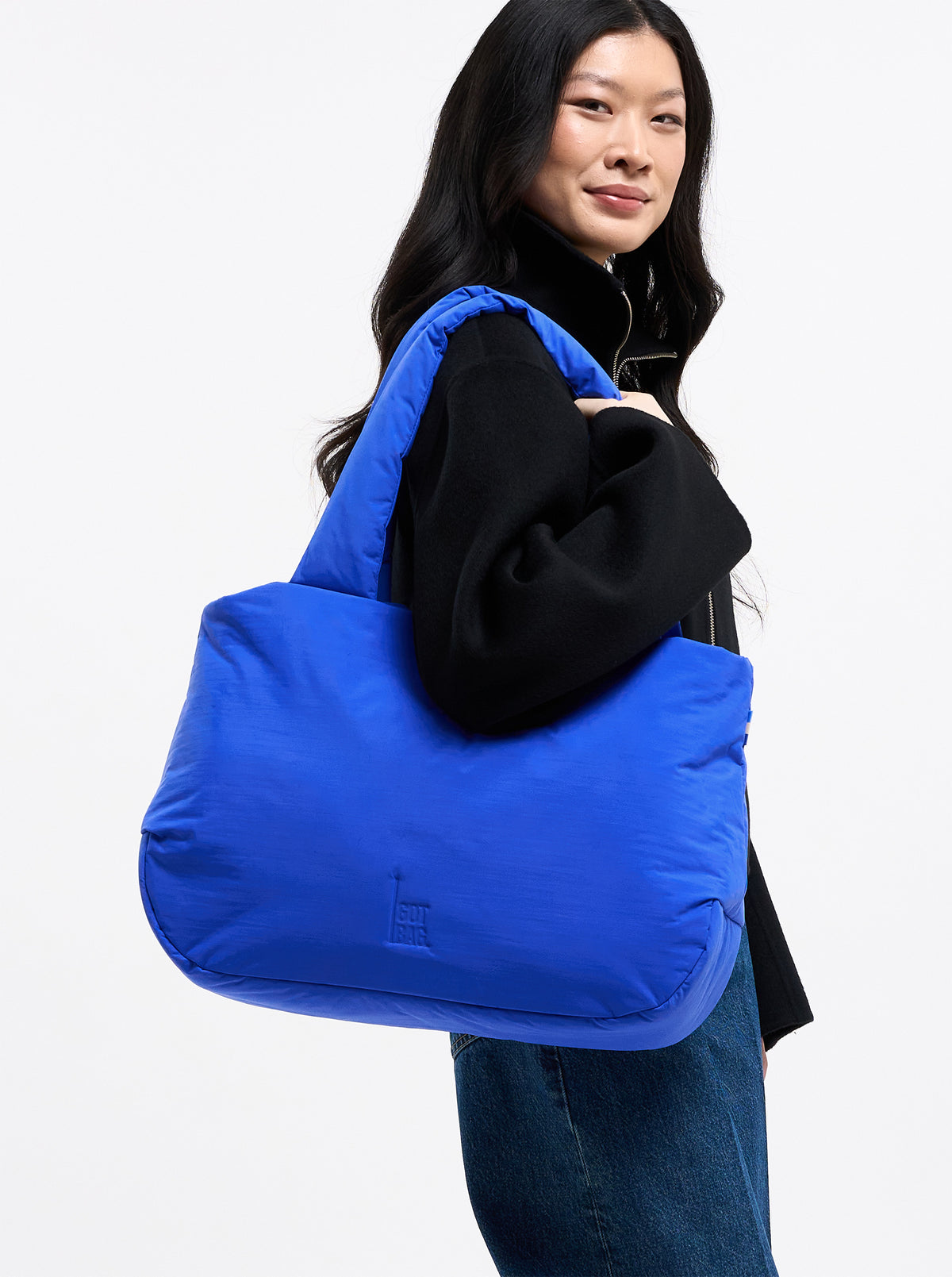 CLOUD HORIZON TOTE BAG Tasche in cobalt (leuchtendes Kobaltblau) von einer Frau über der Schulter getragen.