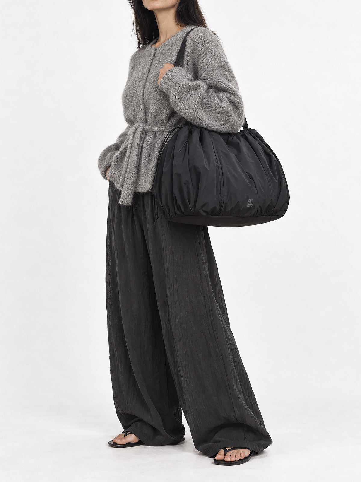 SHELLY TOTE BAG Tasche in black (Schwarz) von einer Frau über der Schulter getragen.
