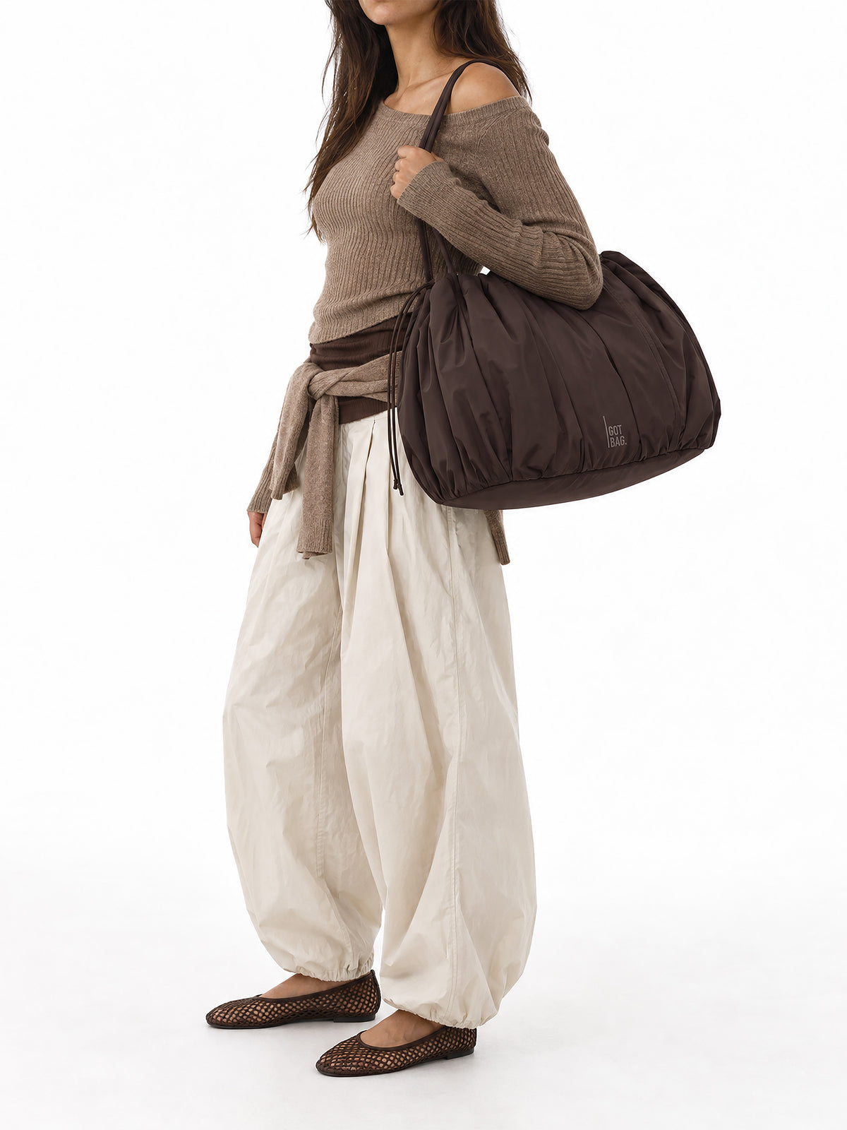 SHELLY TOTE BAG Tasche in sea lion (dunkles Schokobraun) von einer Frau über der Schulter getragen.