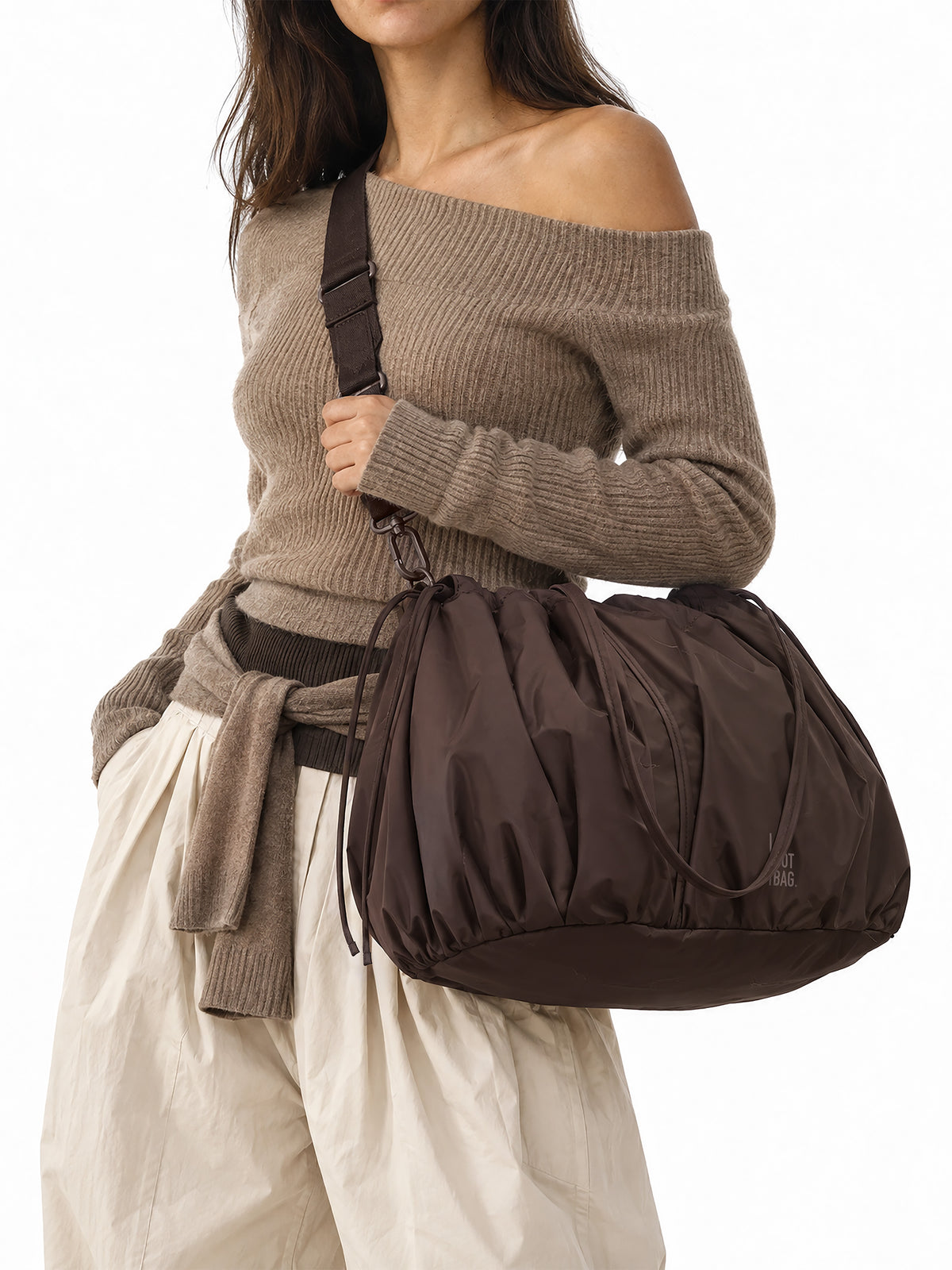 SHELLY TOTE BAG Tasche in sea lion (dunkles Schokobraun) von einer Frau crossbody getragen.