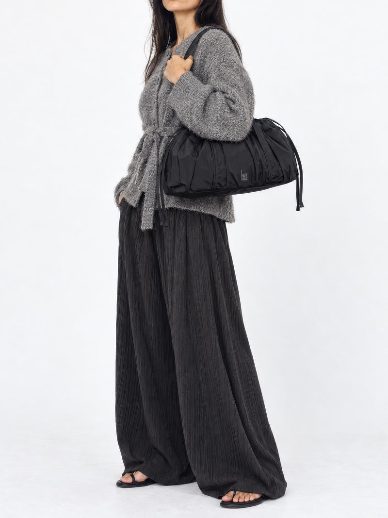 SHELLY SHOULDER BAG Tasche in black (Schwarz) von einer Frau über der Schulter getragen.