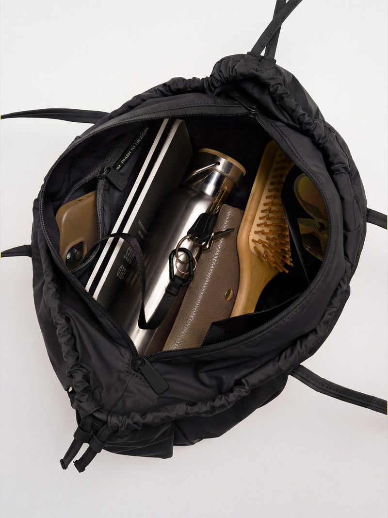 SHELLY SHOULDER BAG Tasche in black (Schwarz) von oben, gefüllt mit Alltagsgegenständen.