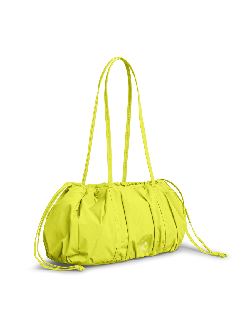 SHELLY SHOULDER BAG Tasche in seagrass (leuchtendes Gelb-Grün) in diagonaler Ansicht.