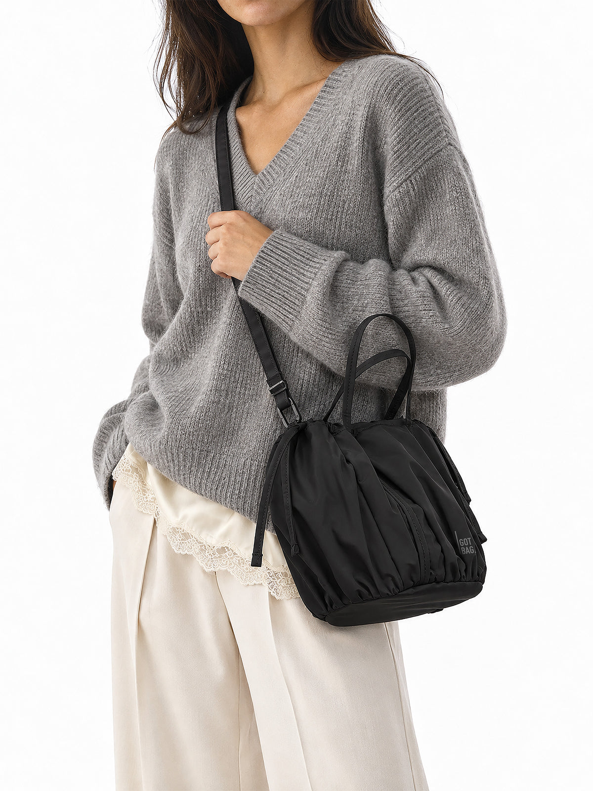SHELLY BUCKET BAG Tasche in black (Schwarz) von einer Frau crossbody getragen.